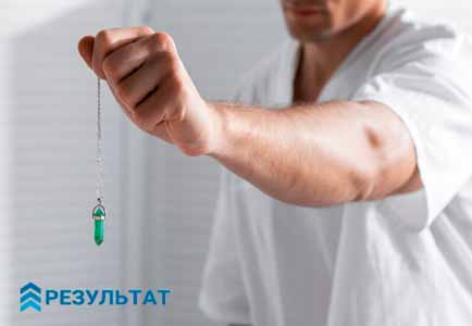 Кулон на цепочке для гипноза в руке врача